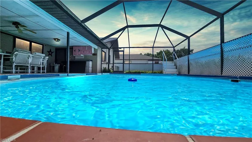 Pool at dusk with glass enclosure and ceiling fan
