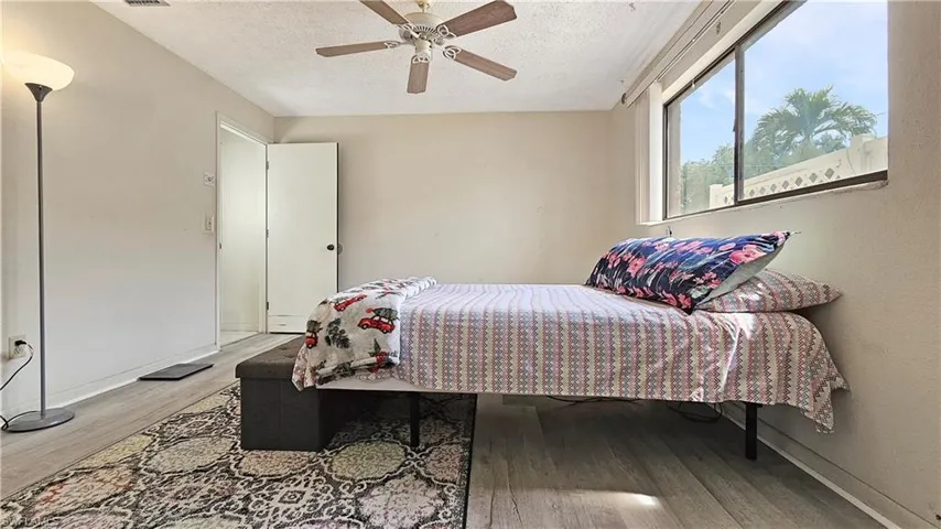Bedroom featuring hardwood / wood-style floors, a textured ceiling, and ceiling fan
