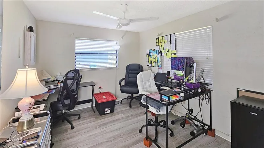 Home office with ceiling fan and light hardwood / wood-style flooring