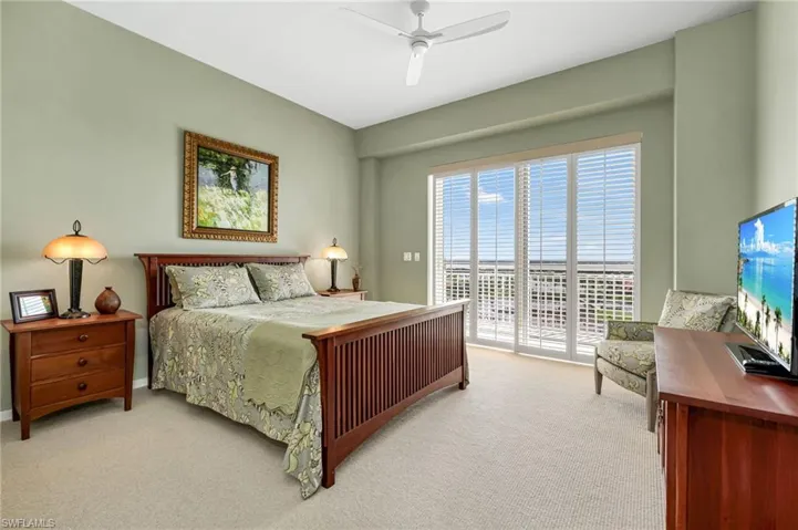 Guest en-suite with soft green tones and sliders that lead to balcony.