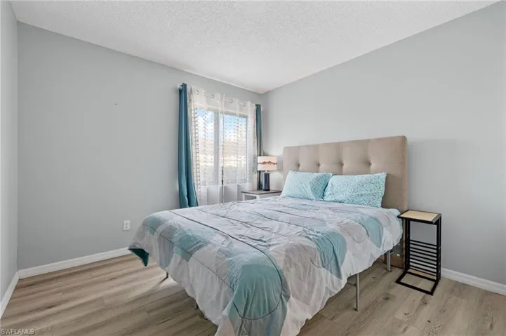 Bedroom with a textured ceiling and light wood-type flooring