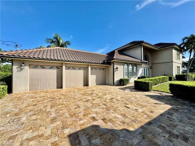 Mediterranean / spanish-style house featuring a garage, stucco siding, and a tiled roof