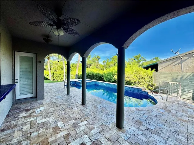 View of pool with a patio, a ceiling fan, and a pool with connected hot tub