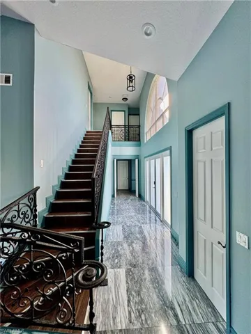 Stairs featuring a high ceiling and a textured ceiling