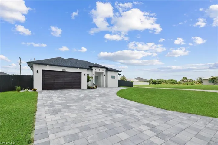 View of front of home featuring a front yard and a garage