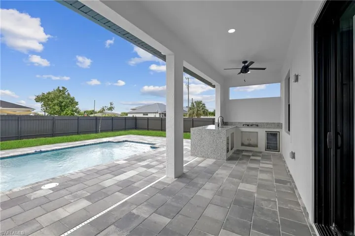View of pool with ceiling fan, sink, a patio area, and area for grilling