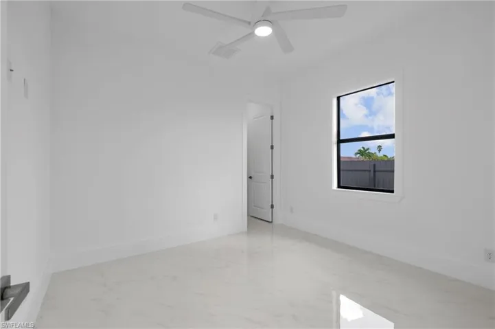 Tiled spare room with ceiling fan