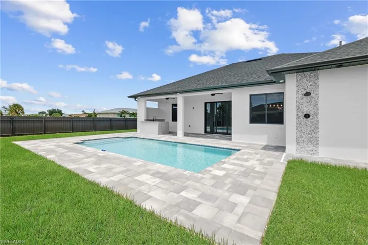 View of swimming pool featuring a patio area and a yard