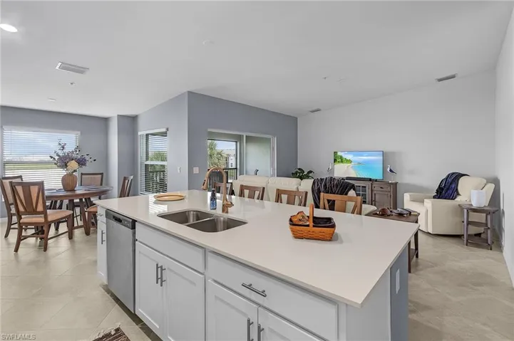 Kitchen featuring a kitchen island with sink, plenty of natural light, sink, and stainless steel dishwasher