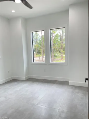 Spare room featuring concrete floors and ceiling fan