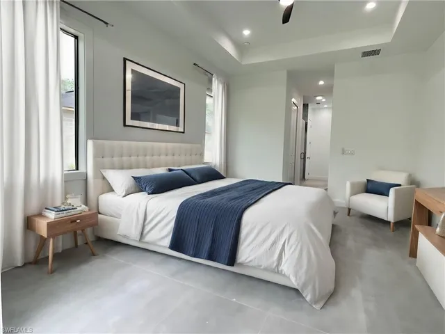 Bedroom with multiple windows, a raised ceiling, and ceiling fan