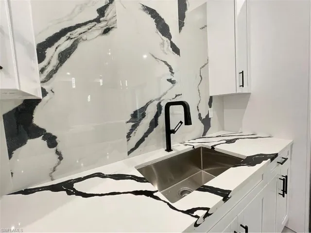 Room details featuring sink and white cabinets
