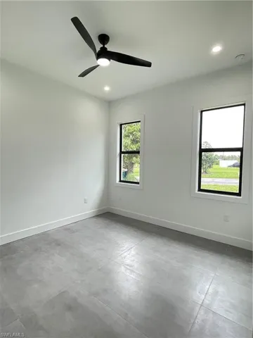 Spare room featuring ceiling fan and concrete flooring