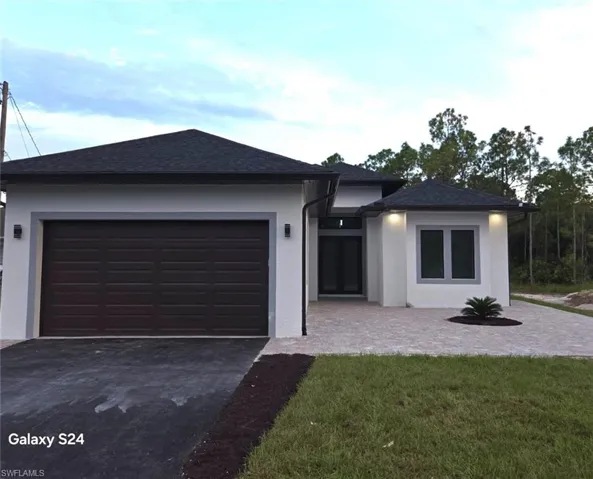 View of front of home featuring a front yard and a garage