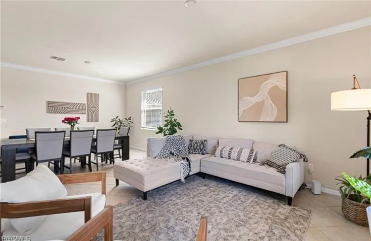 Living room with ornamental molding and light tile patterned flooring