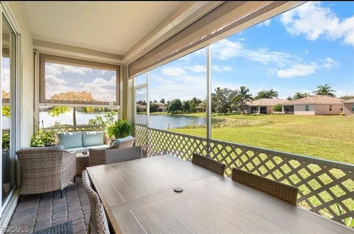 Sunroom / solarium with a water view and an outdoor living / dining area