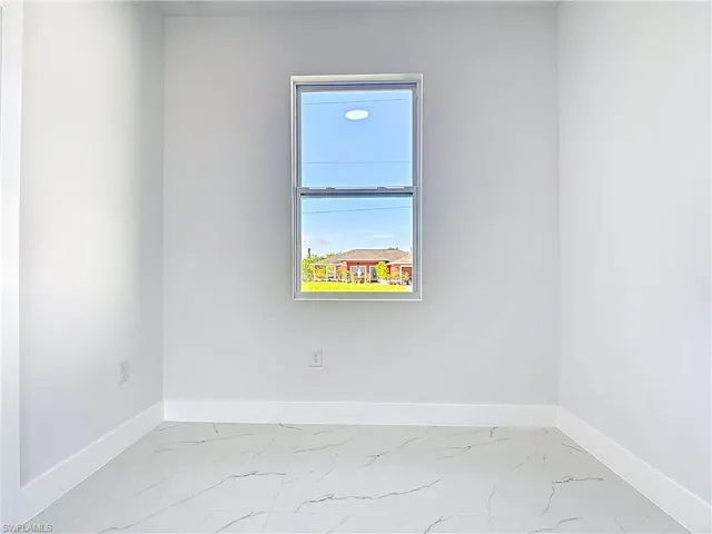 Spare room with baseboards and light marble finish flooring