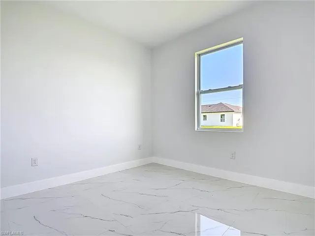 Unfurnished room with baseboards and light marble finish floors