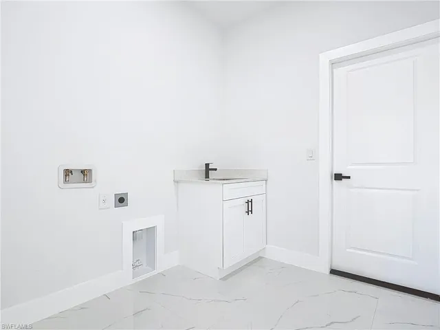 Laundry area featuring hookup for an electric dryer, light marble finish floors, and washer hookup