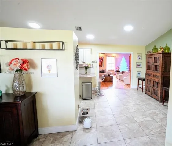 Hall with light tile patterned floors and recessed lighting
