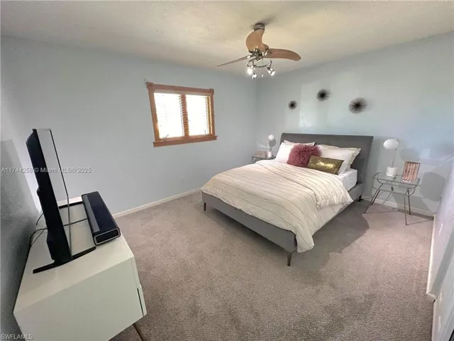 Bedroom with carpet, a textured ceiling, and a ceiling fan