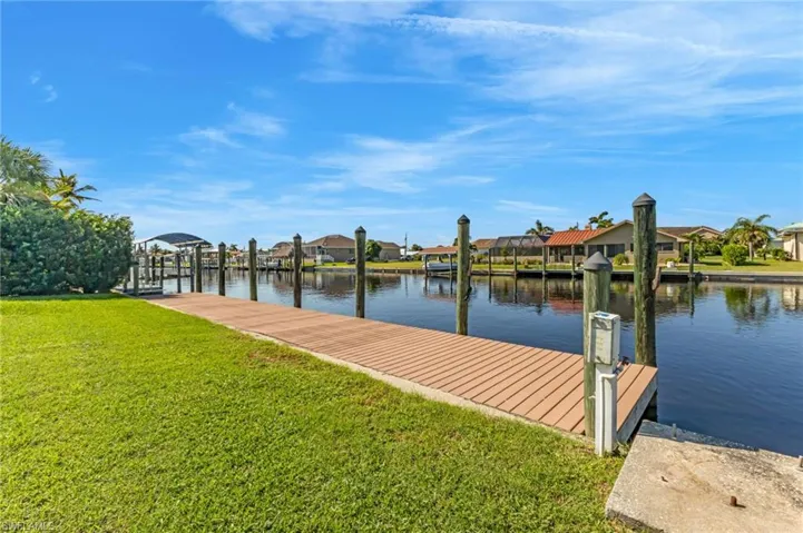 Dock area featuring a lawn, a residential view, and a water view