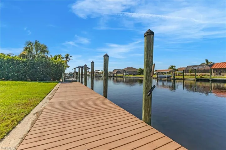Dock featuring a residential view, a water view, and a lawn