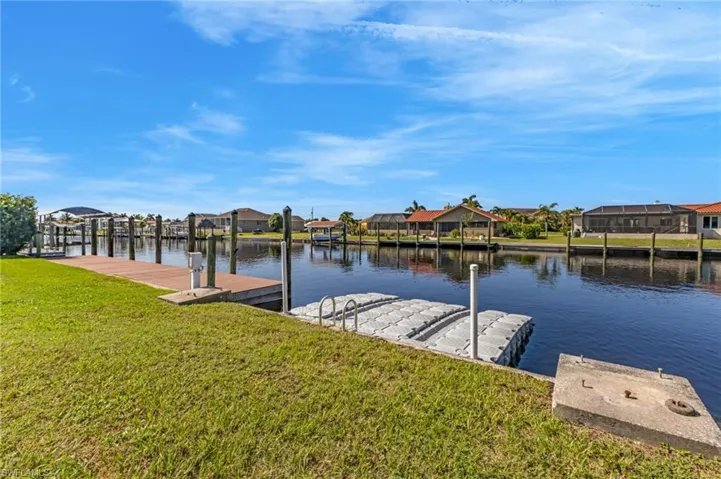 Dock area with a residential view, a water view, and a yard