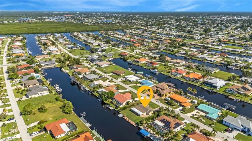 Aerial view of property and surrounding area with a large body of water and nearby suburban area
