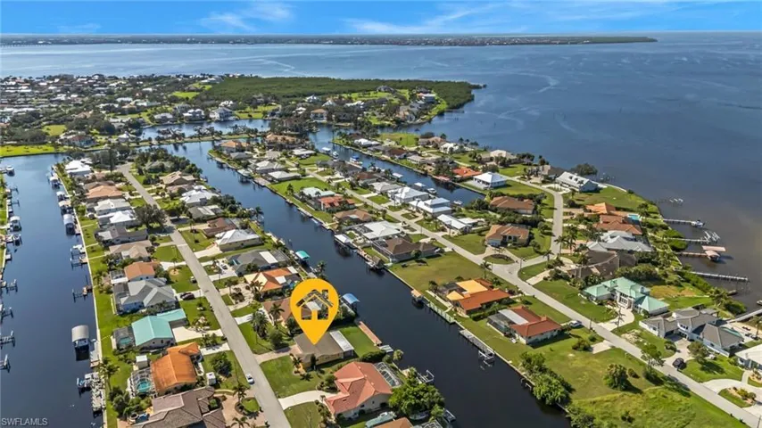 Aerial overview of property's location with a large body of water and nearby suburban area
