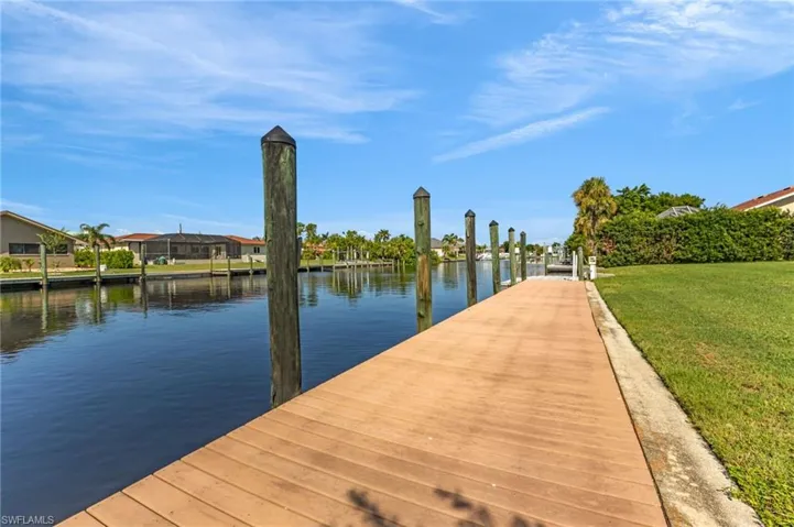 Dock area featuring a water view and a yard