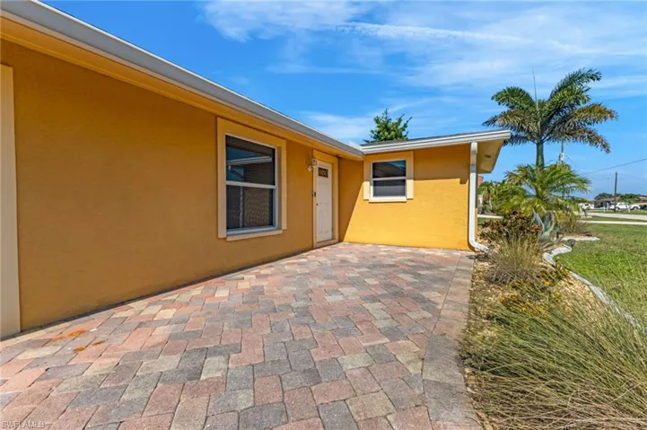 Entrance to property featuring stucco siding and a patio area