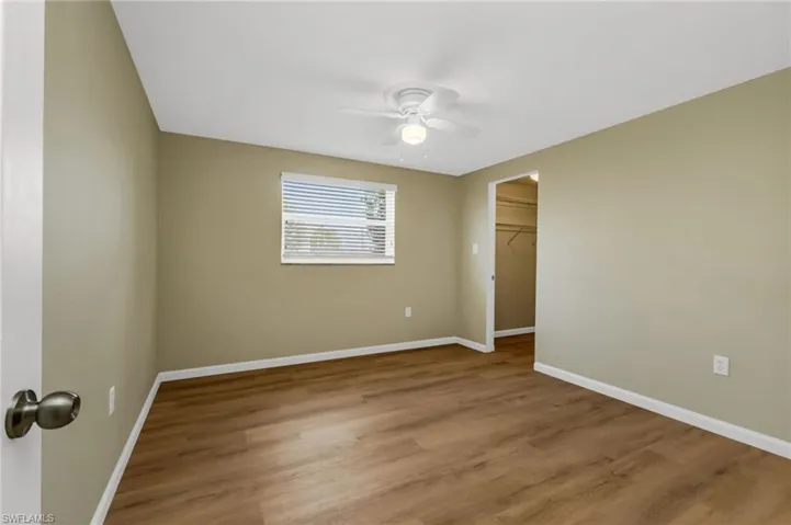 Unfurnished room with wood finished floors and a ceiling fan