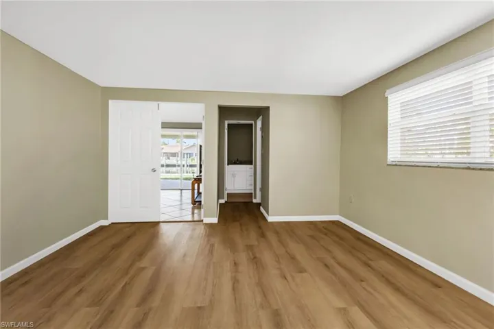 Unfurnished room featuring wood finished floors and baseboards