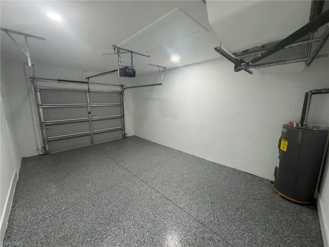Garage featuring water heater and a garage door opener
