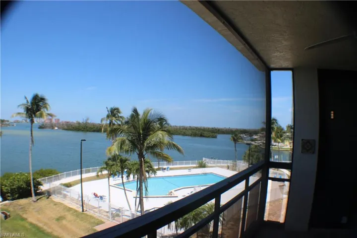 Balcony featuring a community pool and a water view