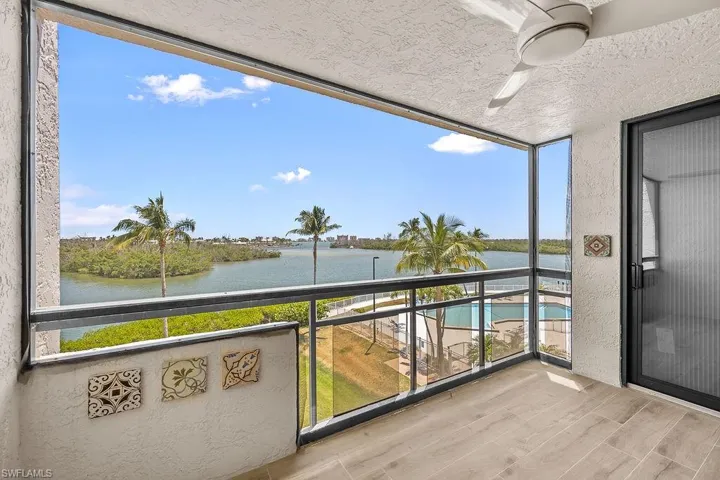 Balcony featuring ceiling fan and a water view