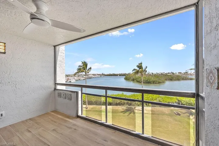 Balcony with a water view and ceiling fan