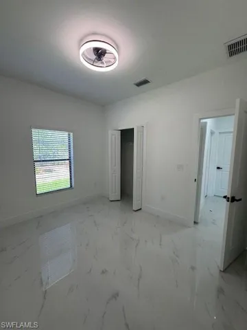 2-Unfurnished bedroom featuring a closet and light marble finish floors