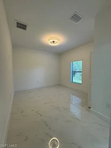 Unfurnished room with baseboards and light marble finish floors