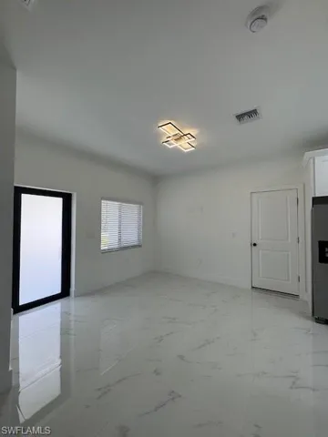 Unfurnished living room featuring light marble finish floors