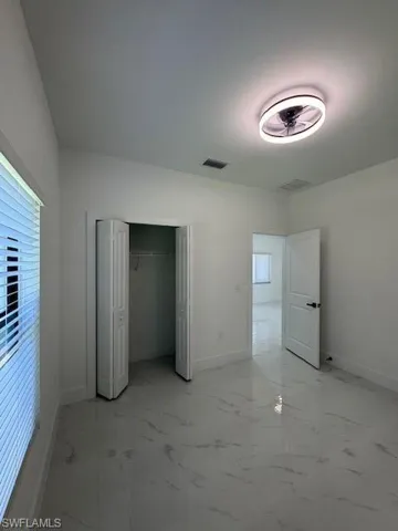 2-Unfurnished bedroom featuring light marble finish flooring and a closet