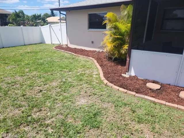 Manicured lawn with a white vinyl fence and gate