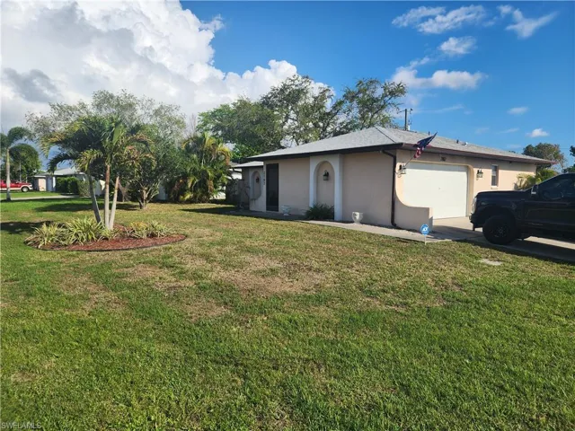 Exterior featuring a light-colored stucco finish, attached garage with a white door, concrete driveway, and a front entry alcove