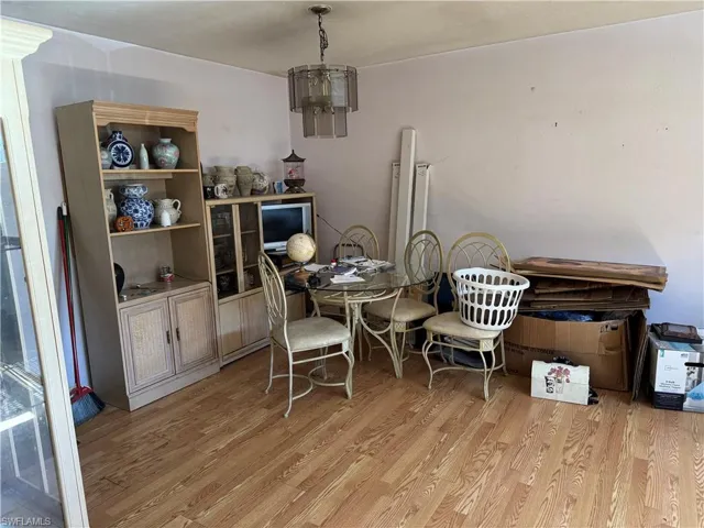 Dining space with a notable chandelier and light wood-type flooring