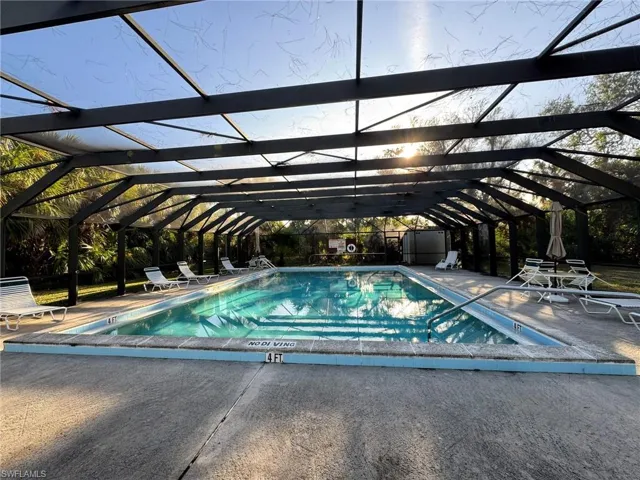 View of pool featuring glass enclosure and a patio area