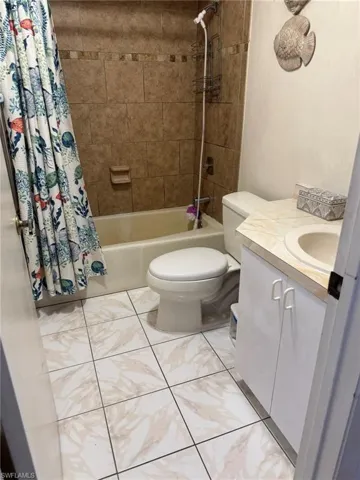 Full bathroom featuring vanity, shower / tub combo, and toilet