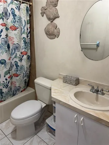 Full bathroom featuring vanity, toilet, and shower / tub combo with curtain