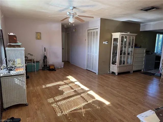 Unfurnished living room featuring ceiling fan, hardwood / wood-style floors, and a textured ceiling