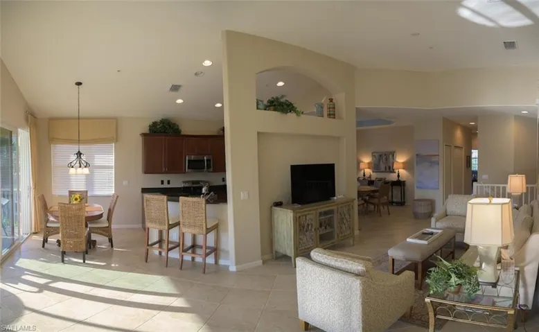 Tiled living room with an inviting chandelier and lofted ceiling